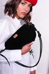 Cartera tipo sobre color bordó, confeccionada en PU tipo gamuza, con correa regulable de nudos chunky y cierre superior.