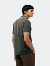 Camisa polo color rosa claro con cuello clásico, tapeta de dos botones y bordado de logo en el pecho. Presenta ribete azul marino en cuello y mangas. Corte clásico.