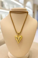Collar con dije de corazón dorado y tiento de gamuza color beige.