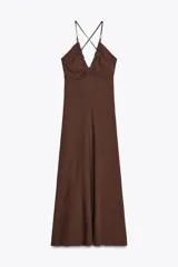 Vestido midi marrón de lino con escote en pico, tirantes finos con abalorios cruzados en la espalda y cierre lateral con cremallera oculta.