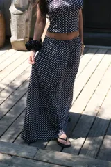 Pollera larga de viscosa con estampado de lunares blancos sobre fondo negro.