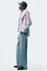 Jeans de cinco bolsillos en denim de algodón rígido, color celeste claro con efecto desgastado. Modelo de corte holgado de cadera a bajo con pierna amplia y tiro caído.