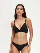Conjunto de ropa interior negro, compuesto por un bralette triangular de algodón con tirantes finos y una bombacha tipo tanga.