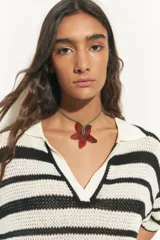 Collar con cordón verde y dije de acrílico rojo con forma de flor.