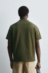 Camiseta verde militar de corte holgado confeccionada en tejido de algodón compacto. Cuello redondo con ribete doble y mangas cortas.