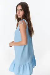 Vestido corto celeste con breteles finos y volados en el ruedo.