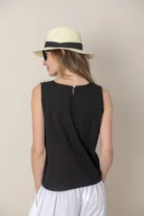Blusa sin mangas de algodón color blanco con bordados florales negros en el frente y escote en V.