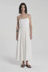Vestido maxi blanco con detalles de encaje y tirantes finos, de corte suelto y largo.