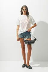 Remera blanca de corte holgado con estampado de círculos rojos.