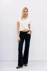 Pantalón jean de tiro medio, calce ajustado, con proceso de coating de acabado símil cuero y pierna levemente acampanada.
