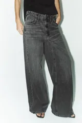 Jeans de tiro alto con pierna ancha y largo completo. Confeccionados en tejido rígido con cinco bolsillos, cintura con trabillas, detalle de costuras torcidas y cierre con cremallera y botón metálico.