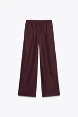 Pantalón palazzo de lino color borgoña, con cintura ajustable con cordones, tiro medio y bolsillos laterales ocultos en la costura.