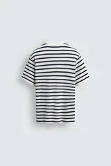 Camiseta de hombre de manga corta, color blanco con rayas horizontales azul marino. Confeccionada en tejido con estructura waffle y corte relaxed fit.