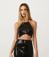 Blusa cropped de lentejuelas negras con cuello halter y espalda descubierta.