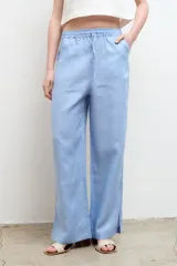 Pantalón color arena, de corte recto y tiro alto, confeccionado en lino.