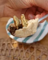 Anillo de diseño orgánico y macizo, realizado artesanalmente en bronce. Presenta una estructura abierta con dos piezas de forma irregular y textura rugosa.