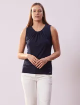 Blusa sin mangas color amarillo, con cuello redondo con frunces delanteros y abertura con botón en la espalda.