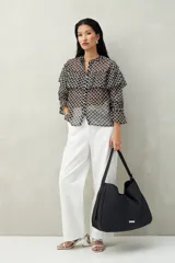 Bolso negro amplio tipo tote bag, confeccionado en poliuretano, con líneas minimalistas y diseño versátil.
