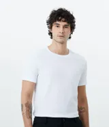 Remera blanca de algodón con textura acanalada, corte slim fit, cuello redondo y mangas cortas.