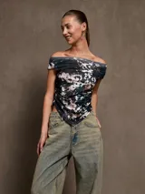 Top negro con escote off-shoulder y corte irregular en el ruedo.