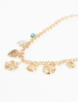 Collar dorado con cadena de eslabones y múltiples dijes colgantes: ojo turco, corazón con reloj, corazón con rosa, flor, sol, moneda y círculo con diseño abstracto.