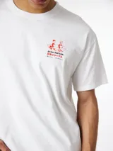 Camiseta blanca de algodón orgánico con corte oversize y estampado en el lateral superior izquierdo y en la espalda con motivos playeros en color rojo.