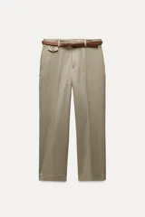 Pantalón de vestir color beige, de tiro alto y corte recto. Incluye cinturón marrón con hebilla metálica. Presenta bolsillos laterales y falsos bolsillos traseros de doble vivo. Cierre frontal con cremallera, botón interior y gancho oculto.