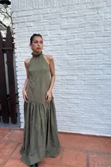 Vestido largo verde oliva de tela simil agamuzada, con escote halter, espalda baja y volados en cuello y cadera.