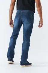 Pantalón jean azul de corte recto con roturas en las rodillas, tiro medio, logo bordado y presillas para cinturón.