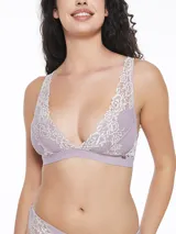 Conjunto de ropa interior lila con detalles de encaje blanco, compuesto por un bralette triangular con breteles regulables y una bombacha tipo tanga.