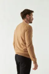 Sweater negro de manga larga con escote en V y logo bordado.