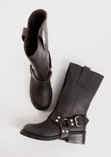 Bota de cuero marrón oscuro con caña media, estribo desmontable y hebilla metálica. Taco de madera de 5cm y suela de caucho.