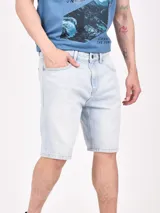 Bermuda de jean celeste claro, corte a la rodilla, con bolsillos delanteros y traseros.