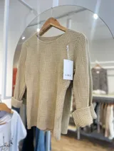 Sweater tejido color beige con diseño geométrico en relieve y mangas 3/4 con puños doblados.