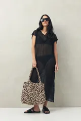 Top largo color blanco, confeccionado en tejido liviano con transparencia y caída fluida.