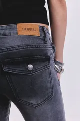 Pantalón de jean negro con tiro bajo y corte acampanado.