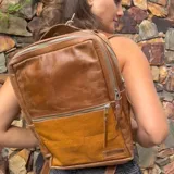 Mochila de cuero vacuno color marrón con diseño geométrico en la parte inferior. Tiene tres compartimentos, uno de ellos acolchado para laptop, y cierre con cremallera.