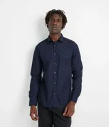 Camisa de vestir azul marino con estampado de lunares blancos, de corte slim fit, con cuello abotonado y mangas largas.