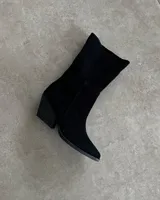 Bota corta plateada de cuero sintético, con punta fina y taco geométrico.