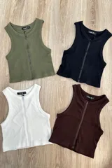 Top tipo musculosa de punto acanalado en color blanco, con cuello redondo y cierre de cremallera frontal.