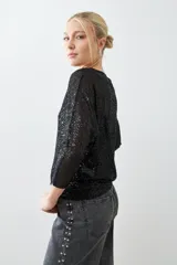 Blusa negra de mangas 3/4 con lentejuelas.