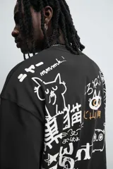 Camiseta negra de corte relaxed fit, cuello redondo y manga corta. Estampado frontal con dibujo de gato y texto en japonés.