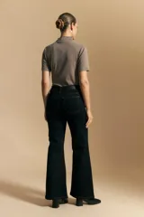 Jean oxford de tiro alto, color azul oscuro, con costuras frontales marcadas y corte acampanado progresivo desde la rodilla.