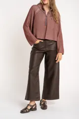 Sweater de punto morado con cierre metálico parcial en el cuello alto y mangas largas.