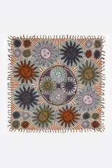 Pañuelo cuadrado de algodón con estampado de soles en tonos marrones, naranjas, rosas y grises.