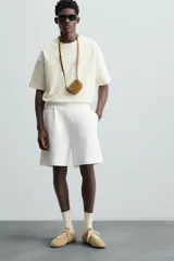 Bermuda color arena de tejido interlock de algodón con elasticidad, corte relaxed fit, cintura elástica ajustable con cordón interior, bolsillos laterales y bolsillo trasero de plastrón.