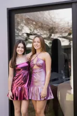 Vestido corto con estampado de rayas horizontales en tonos grises y negros. Diseño con escote halter que se ata al cuello, abertura central en el busto y falda corta con volado.