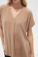 Blusa color beige de lino, holgada y con cuello en V.