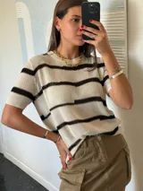 Remera de hilo tejido a rayas horizontales color beige y negro, de mangas cortas y corte suelto.