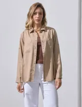 Camisa blanca de lyocell, marca Dash. Tiene cuello con solapa, abertura central con botones, mangas largas regulables con presilla y botón, y dos bolsillos delanteros aplicados.
